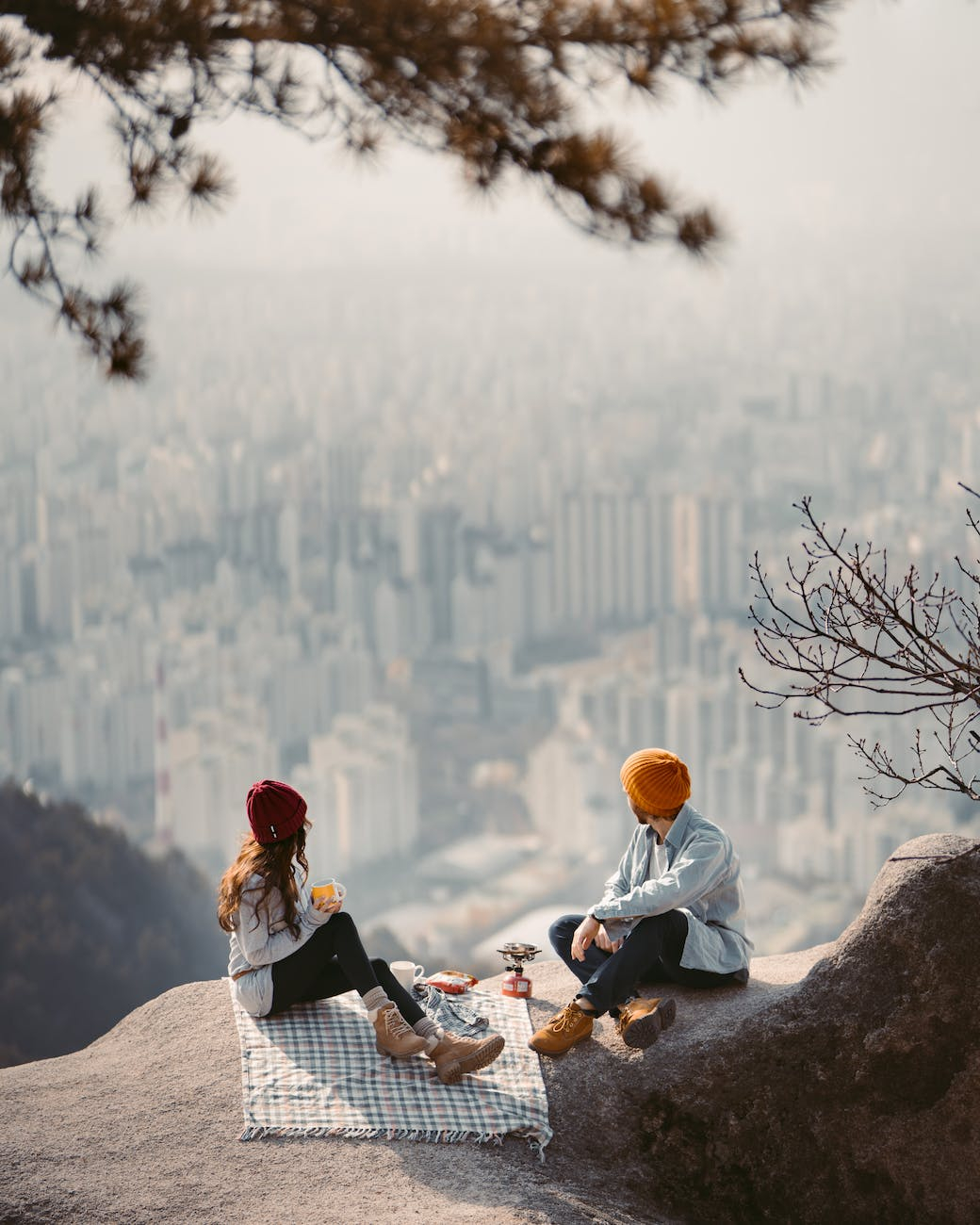 a couple sitting on cliff having a picnic