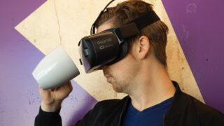 man wearing virtual reality headset and holding a mug